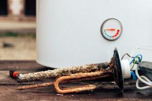 rusted anode rod laid out in front of old water heater